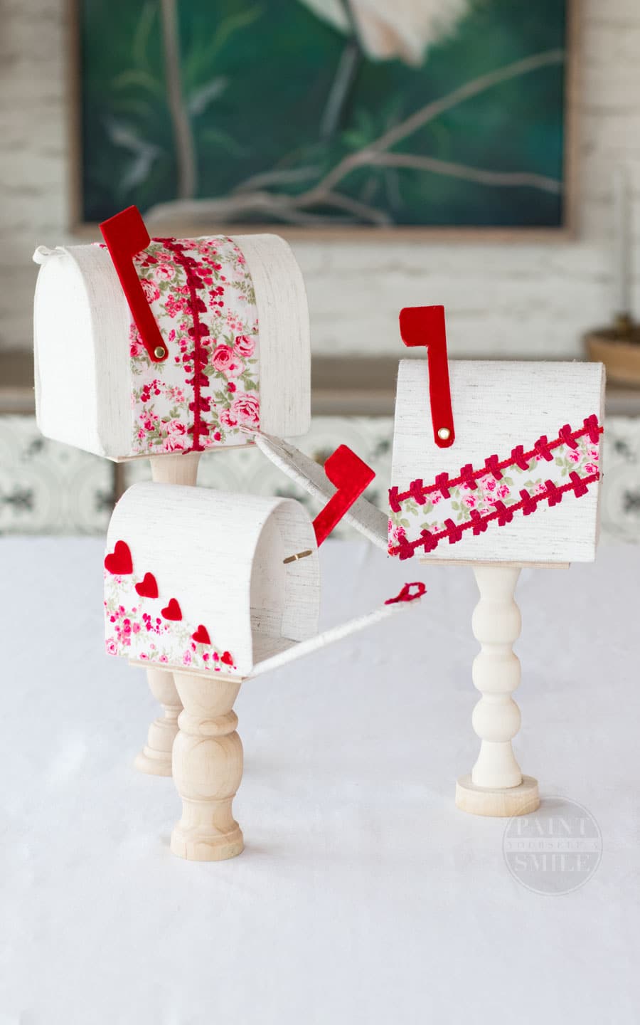 Easy DIY Valentine's Mailboxes made from fabric, cardboard, and wooden candle sticks.