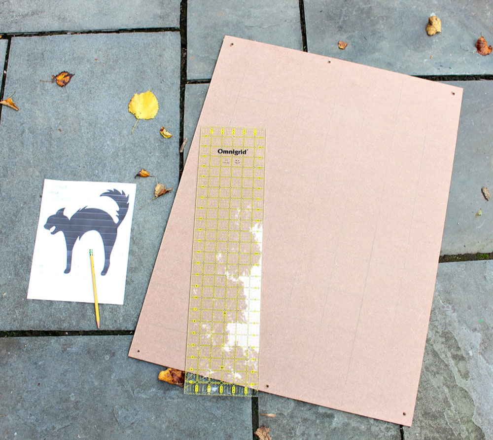 A DIY tutorial to create a large black cat silhouette cut out from wood. Make a statement with a big black cat as part of your Halloween decor. making a grid on MDF