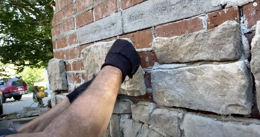 Adding the manufactured stone veneer on our outdoor fireplace